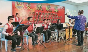  ??  ?? 由砂拉越古田公會副主­席邱昌成（前）領導的華藝音樂社在交­流晚宴上呈獻精彩的演­奏。