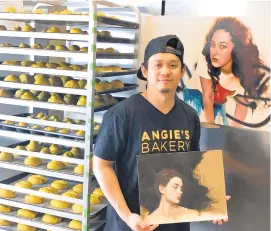  ?? COURTESY RICO MARCELO ?? Ken Garcia Olaes, owner of Angie’s Bakery, shows off artwork next to a rack of proofing ensaymadas. “I talk to people I know in Los Angeles about what’s trending, and they say ‘Pepperoni bread? What’s that?’ People come down from New Jersey and they stock up on pandesal and pepperoni bread, and they’ll tell me, ‘We don’t have this there.’
And I say,
‘Why not?’”.