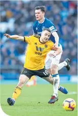  ??  ?? Michael Keane fouls Wolves’ Diogo Jota