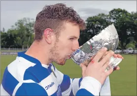  ?? Photograph: Neil Paterson. ?? Newtonmore captain Andy Mackintosh takes a sip from the MacTavish Cup.