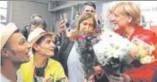  ?? AFP ?? Syrian refugees greet German Chancellor Angela Merkel.