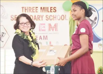  ?? (Ministry of the Presidency photo) ?? First Lady, Sandra Granger (left) presenting a robotics kit to a representa­tive of the Three Miles Secondary School.