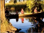  ?? SCOTT HOWELL/NEWS-SENTINEL ?? A dog watches from the shore as a family canoes down the river behind the northwest side Lodi Lake on Wednesday afternoon.