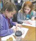  ?? Westside Eagle Observer/SUSAN HOLLAND ?? Two young ladies are busy coloring pages with holiday designs at the Gravette Public Library. The girls were among several who visited the library and enjoyed the coloring activity, holiday treats, free cookies and spiced cider at an open house just before the Gravette Christmas parade.