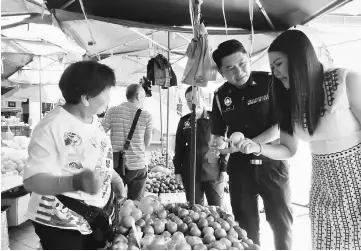  ??  ?? Salihin and Soo inspect fresh apples at a stall.