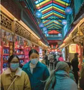  ?? ?? Shoppers eye souvenirs Feb. 28 in Beijing. China’s pandemic recovery and demand in India will drive 2023 growth in Asia,