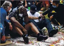  ?? STEPHEN MATUREN — GETTY IMAGES ?? Terrence Floyd, center, attends a vigil Monday where his brother George Floyd was killed by police one week ago in Min-neapolis.