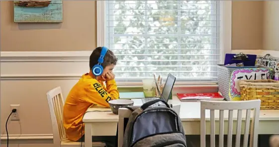  ?? Steve Mellon/Post-Gazette ?? First grader Tyler Brasacchio, 6, during a remote lesson at his Mt. Lebanon home. Experts are researchin­g the impact of remote learning.