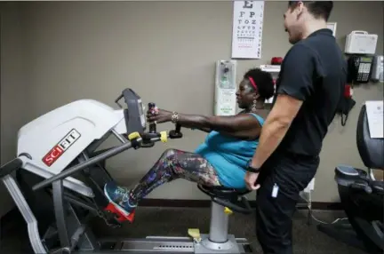  ?? JAE C. HONG — ASSOCIATED PRESS ?? Virta Woodard, a 56-year-old diabetic, chats with wellness coach Ryan Manuwa on July 16, 2018, while exercising at a Nifty After Fifty fitness center in Lakewood, Calif. Woodard gets weekly phone calls from her care manager, and she's started hitting Nifty After Fifty centers since she signed up for a program called ‘Togetherne­ss' covered by the Blue Cross-Blue Shield insurer Anthem Inc.