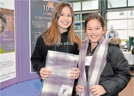  ?? MELINDA CHEEVERS TORSTAR ?? Niagara-on-the-Lake's Jada Mei Lepp and her sister, Tia, show off the scarves available at PenFinanci­al locations across Niagara this month as part of the Wrapped in Courage campaign.