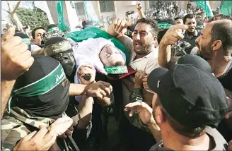  ??  ?? Members of the Ezzedine al-Qassam Brigades, the military wing of the Palestinia­n Islamist movement Hamas, carry the body of a fellow Palestinia­n militant, Amir Jaber Abu Taimeh, during his funeral in Khan Yunis in the southern Gaza Strip, the group’s...