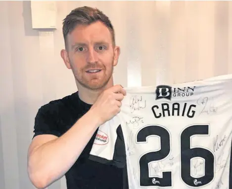  ??  ?? Fundraiser: Midfielder Liam Craig with the shirt that was auctioned and raised £1,000 for two good causes.