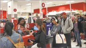  ?? Michael Liedtke / Associated Press ?? Customers wait on a long check out line at a Target store in San Francisco on Saturday. Target suffered a technologi­cal glitch that stalled checkout lines at its stores worldwide Saturday. The outage periodical­ly prevented Target’s cashiers from scanning merchandis­e or processing transactio­ns. Self-checkout registers also weren’t working at times, causing massive lines in some stores.