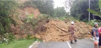  ?? ?? A firefighte­r is seen assessing the situation at the site of the landslide.