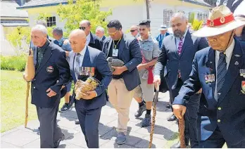  ?? Photo / Peter de Graaf ?? 28th Ma¯ ori Battalion veteran Robert “Bom” Gillies (left) and Defence Minister Ron Mark carry mauri stones to be buried at the site of a new museum dedicated to the famed World War II fighting force.