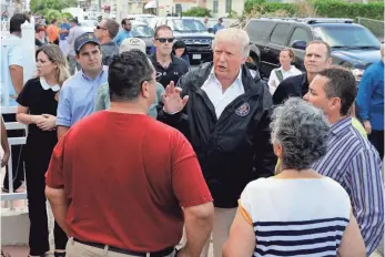  ?? EVAN VUCCI, AP ?? President Trump listens to residents and surveys hurricane damage and recovery efforts Tuesday in a neighborho­od in Guaynabo, Puerto Rico.