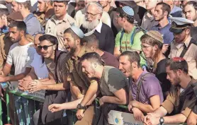  ?? GIL COHEN-MAGEN/AFP VIA GETTY IMAGES ?? Mourners attend the funeral of Israeli settlers Yagel Yaniv and Hillel Yaniv at the military cemetery in Jerusalem on Monday.