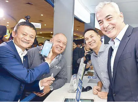  ??  ?? Jack Ma tries the Scan to Pay feature of GCash at the Glorietta cinema ticket booth with Globe president and CEO Ernest Cu, Ayala Land president and CEO Bobby Dy, and Ayala Corporatio­n president and COO Fernando Zobel de Ayala.