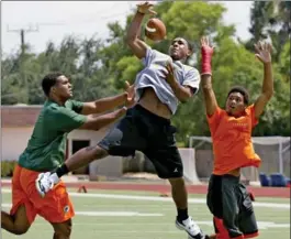  ?? CHARLES TRAINOR JR., TNS ?? Kenny McIntosh catches a ball between his brothers Richard Jr., left, and Deon, who meet Saturday in Miami when the Hurricanes host the Fighting Irish in Week 11 of college play.