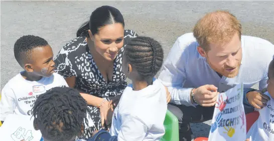  ??  ?? In this September 2019 photo, Prince Harry and Meghan Duchess of Sussex, greet children on their arrival at the Nyanga Methodist Church in Cape Town, South Africa. The couple’s racism allegation­s have raised questions for countries with historic ties to Britain . Photo / via AP