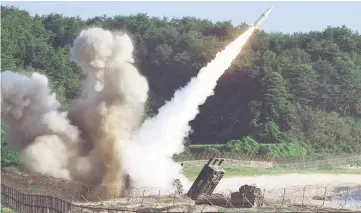  ??  ?? This handout photo provided by South Korean Defence Ministry in Seoul shows US M270 Multiple Launch Rocket System firing an MGM-140 Army Tactical Missile into the East Sea from an undisclose­d location on South Korea’s east coast during a South Korea-US...