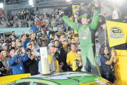  ?? JOE CAVARETTA/STAFF PHOTOGRAPH­ER ?? Kyle Busch celebrates after winning the Ford EcoBoost 400 and the Sprint Cup championsh­ip Sunday at Homestead-Miami Speedway.