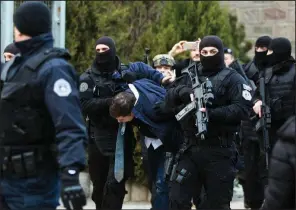  ?? AP/VISAR KRYEZIU ?? Officers carry Serbian negotiator Marko Djuric to a police station in Mitrovic in northern Kosovo on Monday after he was arrested during a protest when he entered the country without permission.