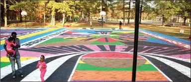  ??  ?? British artist Lakwena Maciver created her OZ Art ARkanvas mural across two adjoining, full-size basketball courts in Pine Bluff’s Martin Luther King Jr. Park.