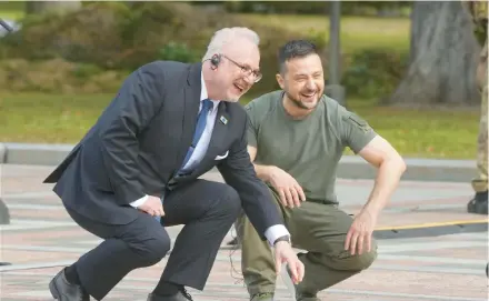  ?? EFREM LUKATSKY/AP ?? Ukrainian President Volodymyr Zelenskyy, right, and Latvian President Egils Levits smile Friday at the Walk of the Brave in Kyiv. The Walk of the Brave honors those who have helped in the struggle against Russia’s invasion of Ukraine.