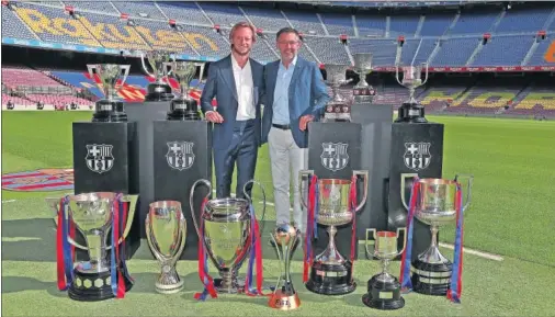  ??  ?? Rakitic posa en el Camp Nou junto a Bartomeu con todos los trofeos conquistad­os en sus seis temporadas en el Barça.