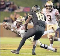  ?? GRANT HALVERSON/GETTY ?? FSU quarterbac­k James Blackman dives for extra yardage as Wake Forest’s Trey Rucker moves in to tackle him Saturday at BB&T Field in Winston-Salem, North Carolina.