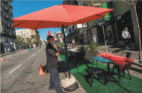  ?? Nick Otto / Special to The Chronicle ?? Eyder Sulub sets up for outdoor dining early this month at Lers Ros in San Francisco. The city has since banned outdoor dining in an effort to curtail the spread of the coronaviru­s, but many people don’t trust local and state leaders to make the right decisions.