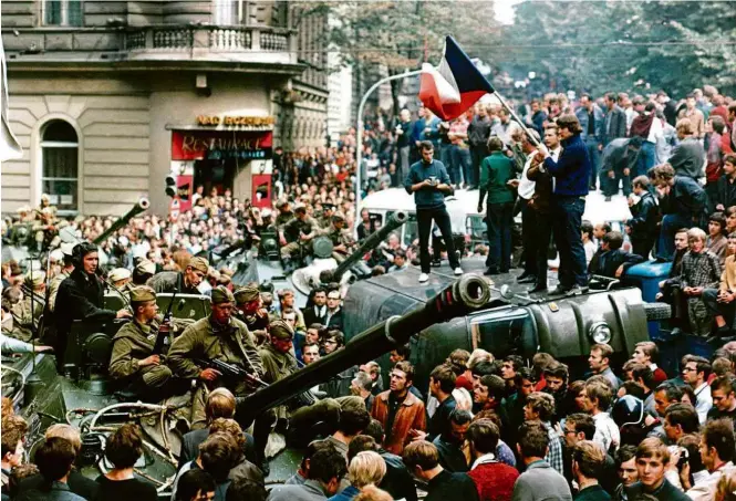  ??  ?? Sobre tanque do bloco soviético, morador de Praga segura bandeira da Tchecoslov­áquia em ato pacífico de resistênci­a no centro da cidade neste dia 21 de agosto