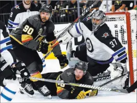  ?? Chasesteve­ns ?? Las Vegas Review-journal @csstevensp­hoto Erik Haula, center, and Knights teammate Tomas Tatar (90) attack against Winnipeg goaltender Connor Hellebuyck in the first period of Game 3 at T-mobile Arena.