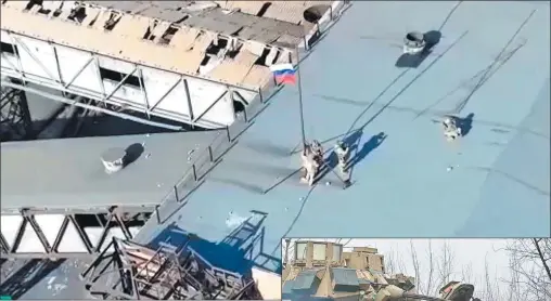  ?? AFP ?? IMÁGENES. Tanques ucranianos se alejan de Adviika, mientras tropas rusas izan la bandera en el techo de un devastado edificio.