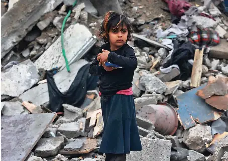  ?? AFP ?? A young Palestinia­n girl stands amid the rubble of a building hit by Israeli bombardmen­t in Rafah in the southern Gaza Strip on Sunday.