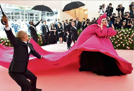  ??  ?? There is probably no theme more fitting for Lady Gaga than camp. The star made an appearance wearing a voluminous bright pink dress that she shed on the red carpet to reveal three other outfits. — Photos: agencies