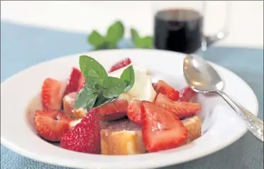  ??  ?? Fresh strawberri­es are served over angel food cake along with a dollop of vanilla ice cream and a sprig of mint leaves.