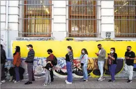  ?? Matias Basualdo Associated Press ?? VOTERS line up Sunday in Santiago for a plebiscite on a progressiv­e draft of the Chilean Constituti­on to replace one dating from the 1973-90 dictatorsh­ip.