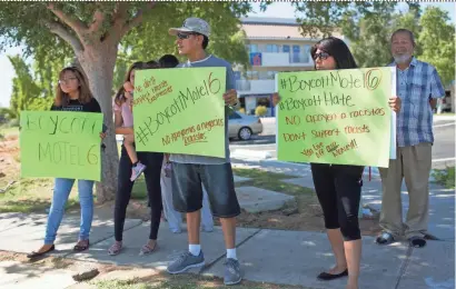  ?? THOMAS HAWTHORNE/THE REPUBLIC ?? Protesters hold signs urging a boycott of Motel 6 in front of one of the hotel’s Phoenix locations on Friday.