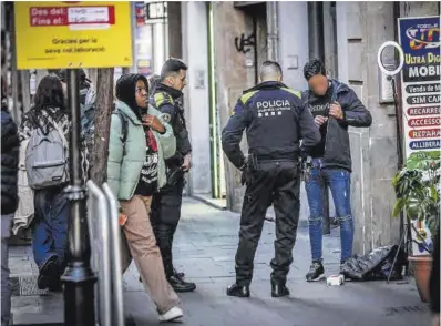  ?? Jordi Otix ?? Dos mossos se llevan a un joven arrestado, en la Boqueria.