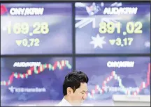  ??  ?? In this file photo, a currency trader looks at computer monitors near screens showing the foreign exchange rates at the foreign exchange dealing room
in Seoul, South Korea. (AP)