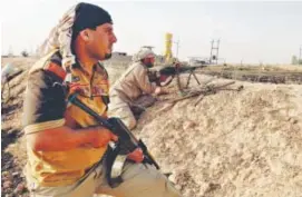  ??  ?? Fighters with the “Peace Brigades” hold their positions Friday on the outskirts of Samarra, 60 miles north of Baghdad. Loay Hameed, The Associated Press