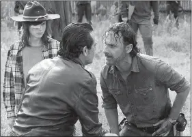  ??  ?? In a tense scene from last season’s finale, Rick (Andrew Lincoln, right) faces off against Negan (Jeffrey Dean Morgan) as Rick’s son, Carl (Chandler Riggs), looks on. The Walking Dead returns today to AMC.