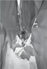  ?? Photo for The Washington Post by Dina Mishev ?? ■ A hiker navigates an easy sandstone slot canyon at Grand Staircase-Escalante National Monument.