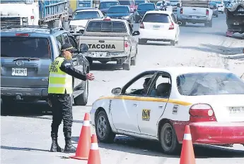  ?? FOTOS: EFRAÍN MOLINA. ?? LABOR. Agentes de la Utevi están pendientes de la circulació­n de los taxis para detectar cualquier irregulari­dad en estos. Una de esas es la doble numeración.