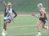  ?? STAFF PHOTO BY ANDY STATES ?? North Point’s Lia Willis looks to run past Patuxent’s Kayleigh Murphy during first-half action on Wednesday night at North Point. Willis scored three goals, but Patuxent won 14-9.