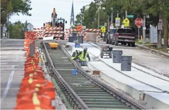  ?? RICK WOOD / MILWAUKEE JOURNAL SENTINEL ?? Workers prepare tracks on Ogden Ave. near Farwell Ave. this month as work continues on the Milwaukee streetcar project.