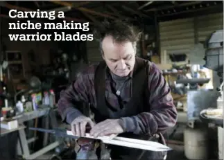  ?? SETH WENIG — THE ASSOCIATED PRESS ?? John Lundemo works on an unfinished sword at his workshop in New Hampton, N.Y., Thursday.