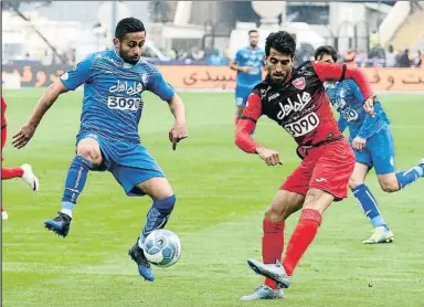  ?? ATTA KENARE / AFP ?? Vahid Amiri, del Persépolis, golpea el balón ante Omid Ebrahimi, izquierda, del Esteghlal